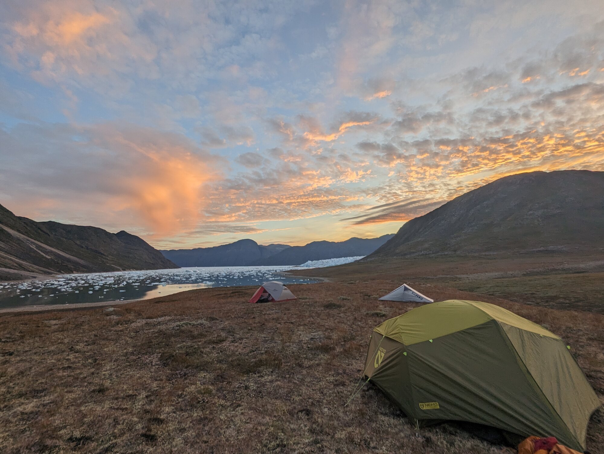 Field camp beside a glacier and an iceberg-filled fjord